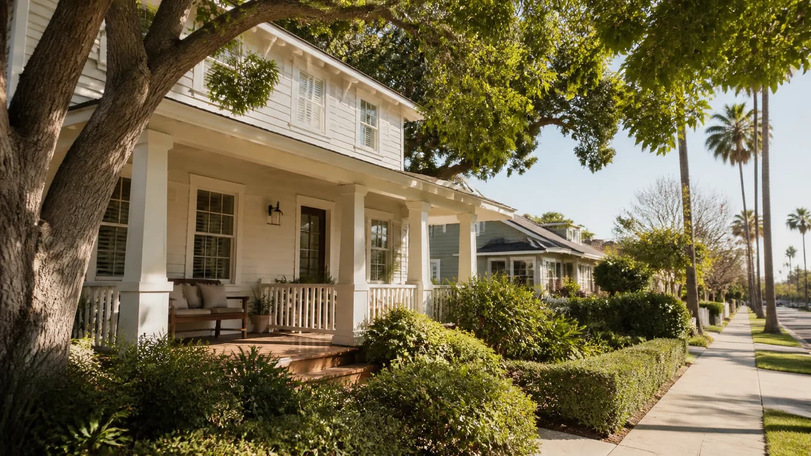 Illustrative porch-front Craftsman home on a tree-lined Coronado Village street.