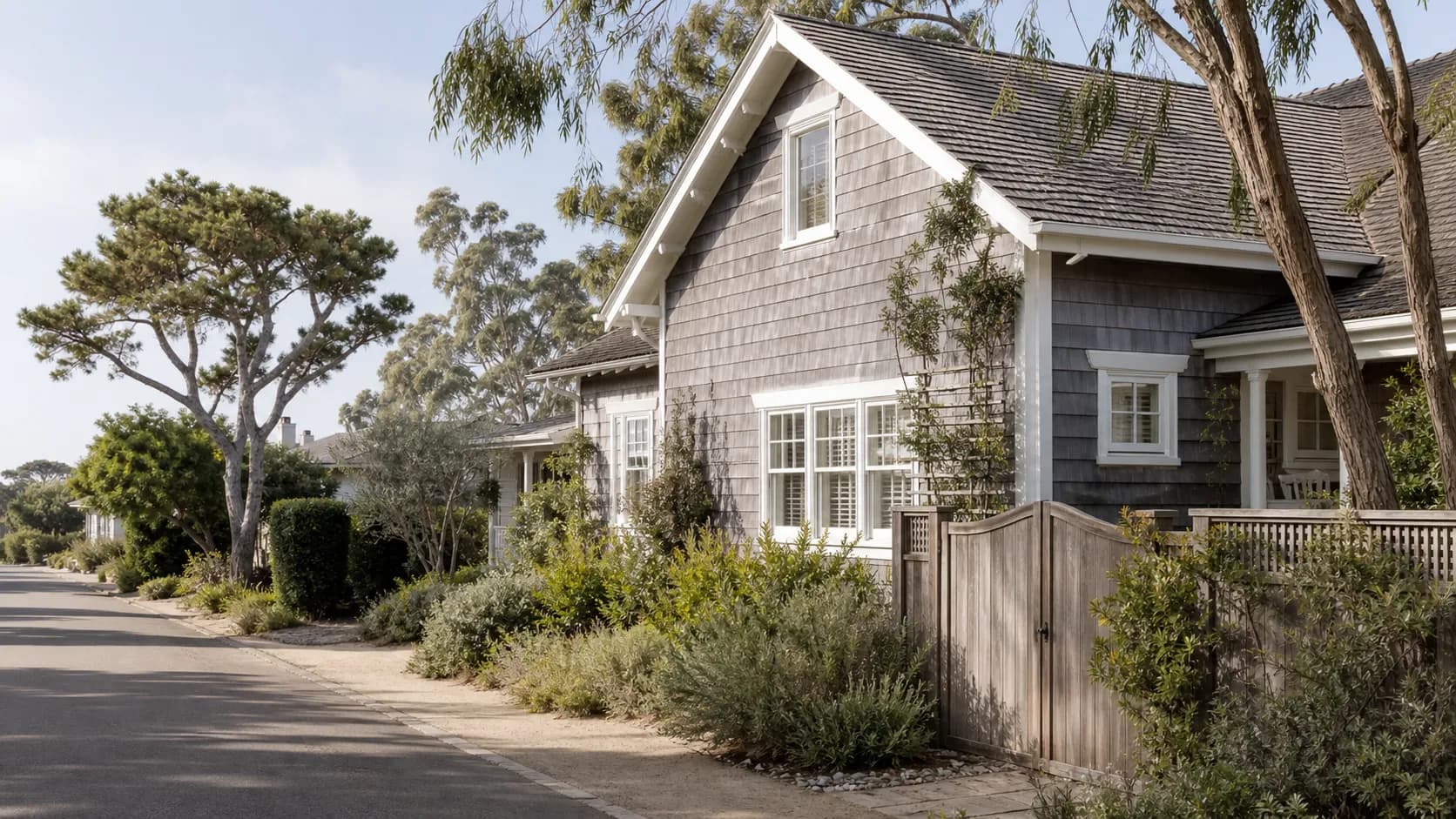 Illustrative gray shingle coastal cottage on a eucalyptus-lined Del Mar residential street.
